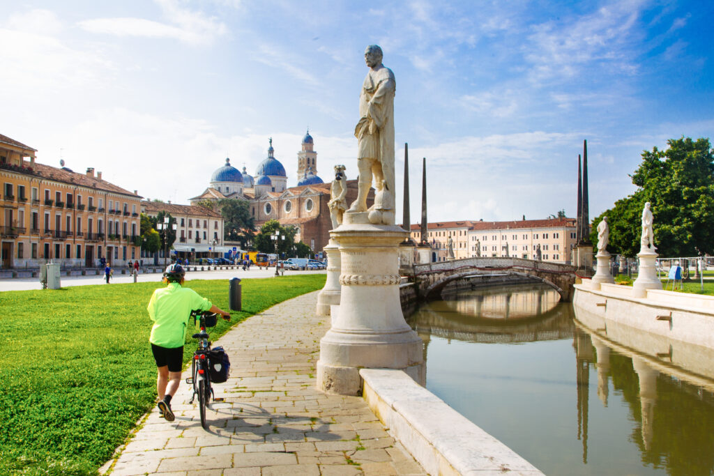 Radfahrer auf dem Prato della Valle in Padua mit Blick zur Basilika Santa Giustina