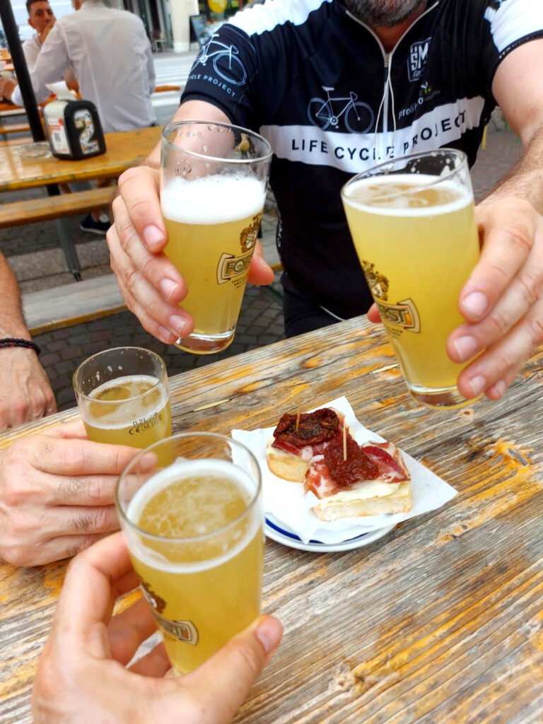 Radfahrer stoßen mit einem Glas Craft-Bier an